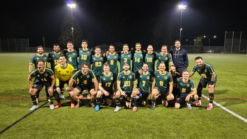 The Brazuca FC squad in green and gold kits on the pitch under the floodlights